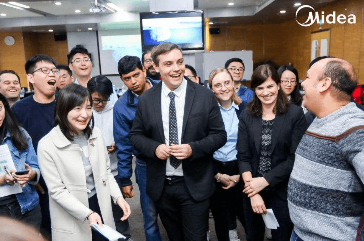 Alex Amiri with International Voyager programme participants in a training room at Midea